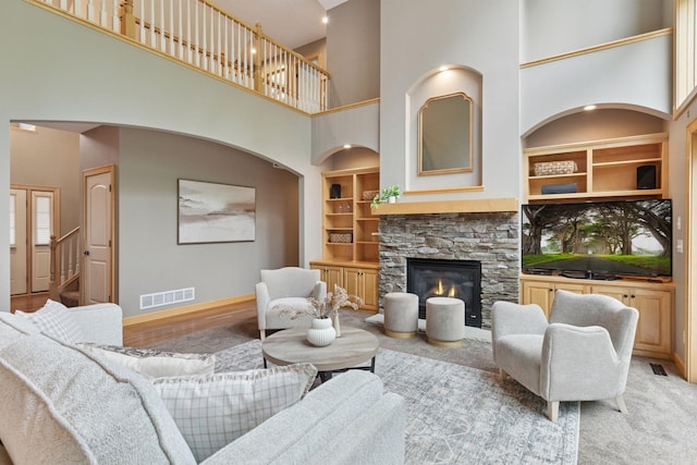 9885 Troy Ln N, Maple Grove, MN 55311 - living area featuring a high ceiling, baseboards, built in features, a fireplace, and arched walkways
