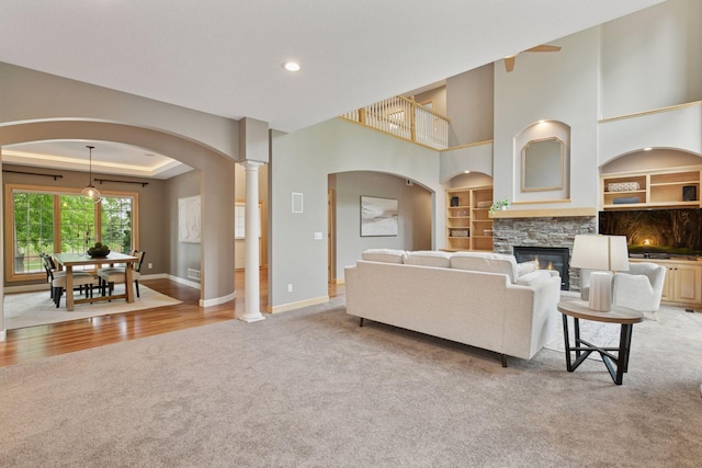 9885 Troy Ln N, Maple Grove, MN 55311 - living room featuring light carpet, built in shelves, baseboards, a fireplace, and recessed lighting