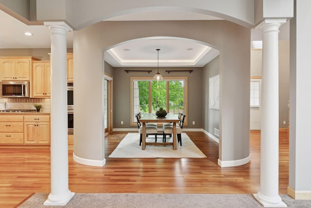 9885 Troy Ln N, Maple Grove, MN 55311 - dining room featuring light wood-style floors, baseboards, arched walkways, a tray ceiling, and recessed lighting