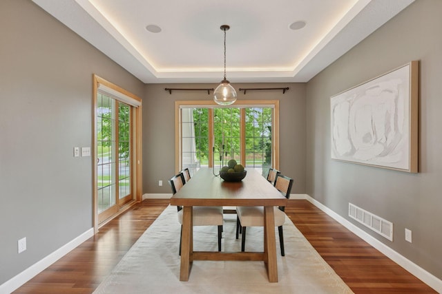 9885 Troy Ln N, Maple Grove, MN 55311 - dining space featuring a tray ceiling, wood finished floors, and baseboards