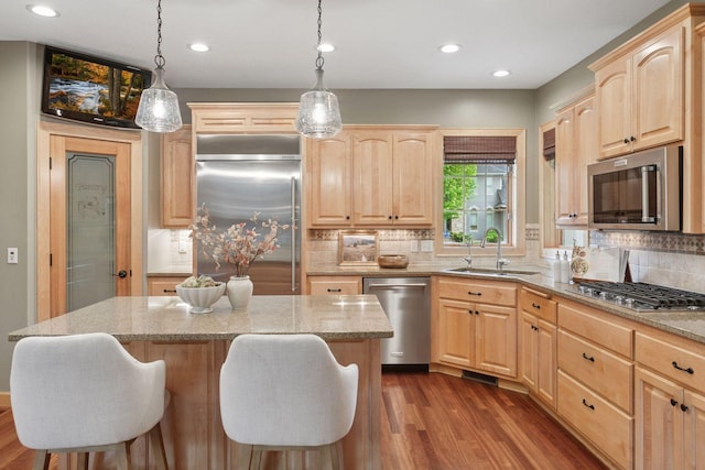 9885 Troy Ln N, Maple Grove, MN 55311 - kitchen with light brown cabinetry, appliances with stainless steel finishes, a sink, light stone counters, and recessed lighting