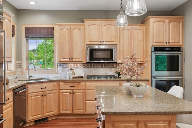 9885 Troy Ln N, Maple Grove, MN 55311 - kitchen with light brown cabinets, appliances with stainless steel finishes, a sink, light stone counters, and recessed lighting