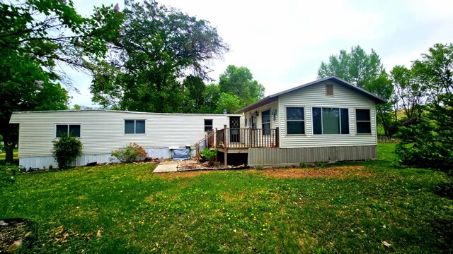 33798 Shady Oak Dr, Foster Twp, MN 56225 - rear view of house with a wooden deck and a lawn