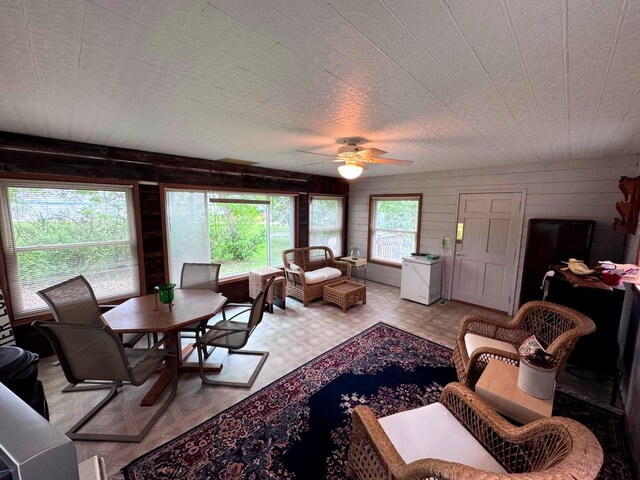 33798 Shady Oak Dr, Foster Twp, MN 56225 - living area featuring a ceiling fan, wood walls, and tile patterned floors
