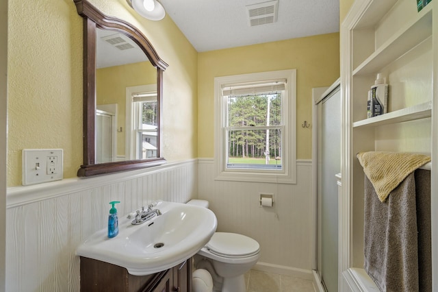 3364 85th Ave, Princeton, MN 55371 - bathroom featuring a wainscoted wall, a stall shower, toilet, vanity, and tile patterned flooring