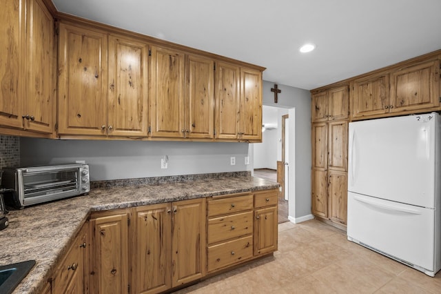 3364 85th Ave, Princeton, MN 55371 - kitchen with freestanding refrigerator, dark countertops, brown cabinets, recessed lighting, and light tile patterned floors