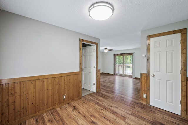 3364 85th Ave, Princeton, MN 55371 - empty room featuring wood finished floors, a wainscoted wall, a textured ceiling, and wood walls