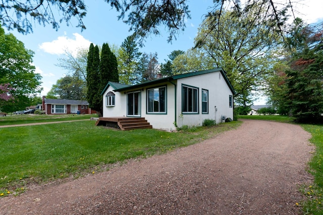915 Knapp St, Rice Lake, WI 54868 - ranch-style house featuring dirt driveway, stucco siding, a front lawn, and a chimney