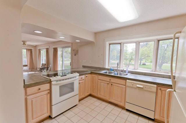 915 Knapp St, Rice Lake, WI 54868 - kitchen featuring white appliances, a sink, light brown cabinetry, light tile patterned floors, and a peninsula