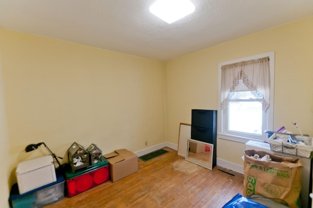 915 Knapp St, Rice Lake, WI 54868 - misc room featuring light wood-style flooring, baseboards, and a textured ceiling