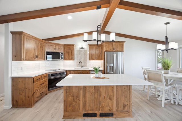 67854 217th St, Darwin, MN 55324 - kitchen featuring stainless steel appliances, a chandelier, a sink, brown cabinetry, and backsplash