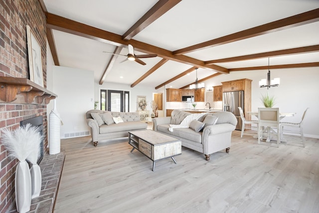 67854 217th St, Darwin, MN 55324 - living area with a chandelier, light wood-style floors, a ceiling fan, a brick fireplace, and baseboards