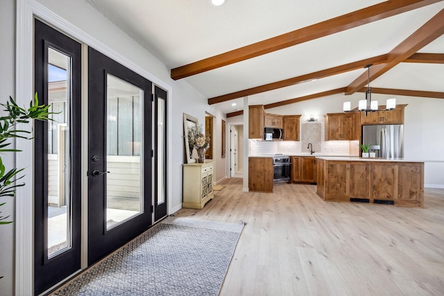 67854 217th St, Darwin, MN 55324 - kitchen featuring stainless steel appliances, brown cabinetry, light wood-style flooring, a chandelier, and light countertops