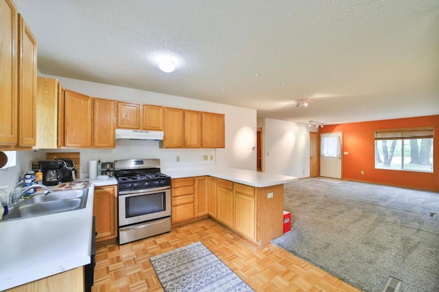 18917 Hartley Lake Rd, Brainerd, MN 56401 - kitchen with stainless steel gas range oven, under cabinet range hood, a textured ceiling, open floor plan, and a peninsula