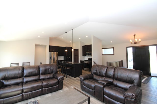 1707 17th St NW, Willmar, MN 56201 - living room with light wood-style floors, vaulted ceiling, and a chandelier