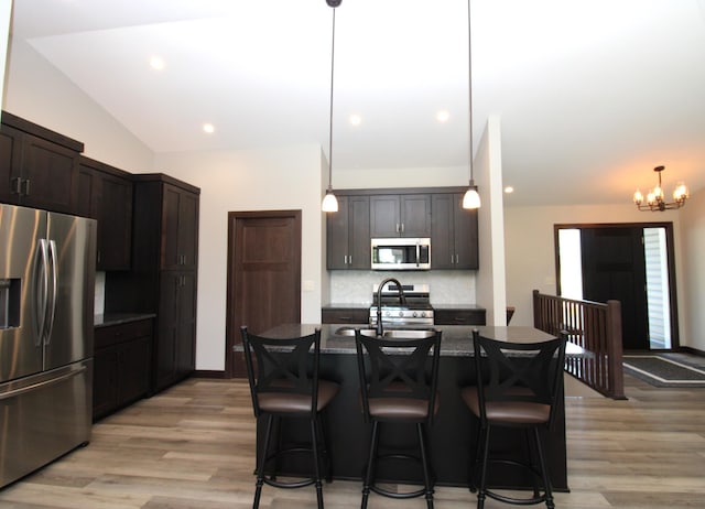 1707 17th St NW, Willmar, MN 56201 - kitchen with appliances with stainless steel finishes, a sink, light wood-style floors, a breakfast bar, and recessed lighting