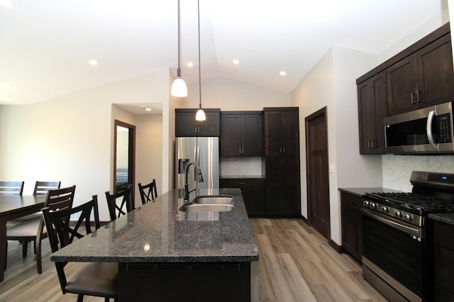 1707 17th St NW, Willmar, MN 56201 - kitchen featuring appliances with stainless steel finishes, a sink, a breakfast bar area, decorative backsplash, and light wood-style flooring
