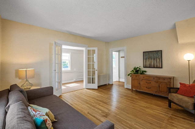 3545 Minnehaha Ave, Minneapolis, MN 55406 - living room featuring french doors, wood finished floors, a baseboard radiator, radiator heating unit, and a textured ceiling