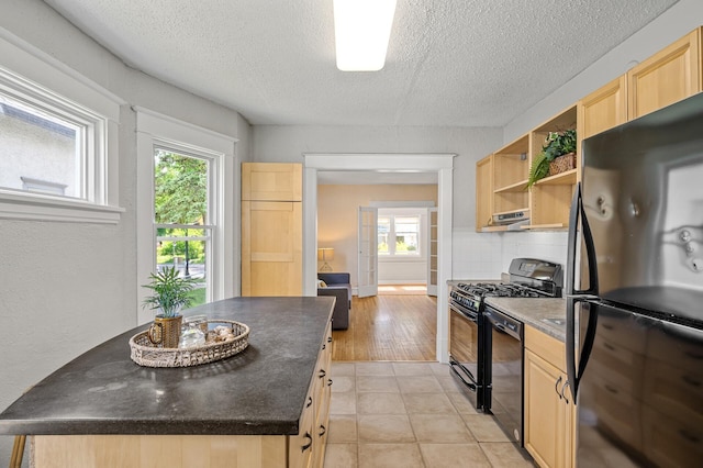 3545 Minnehaha Ave, Minneapolis, MN 55406 - kitchen with black appliances, light brown cabinets, dark countertops, under cabinet range hood, and a textured ceiling