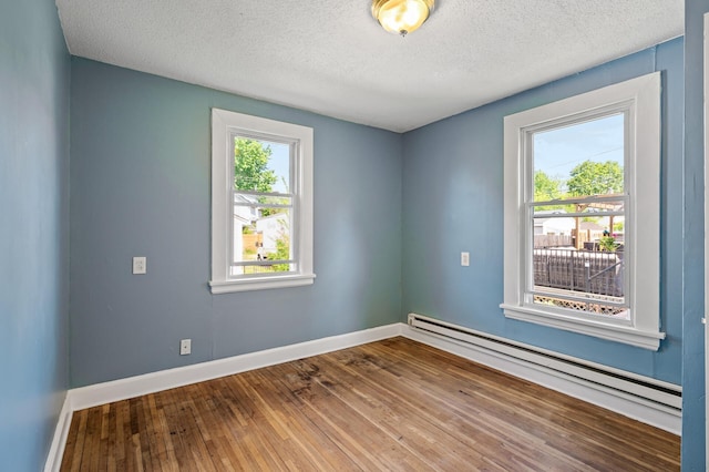 3545 Minnehaha Ave, Minneapolis, MN 55406 - empty room featuring a baseboard heating unit, hardwood / wood-style flooring, baseboards, and a textured ceiling