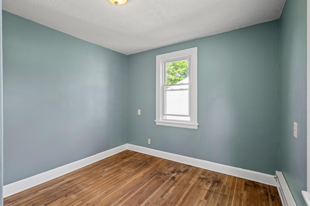 3545 Minnehaha Ave, Minneapolis, MN 55406 - unfurnished room with a baseboard radiator, baseboards, wood finished floors, and a textured ceiling
