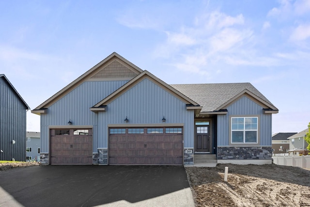 249 3rd St SW, Delano, MN 55328 - view of front of property with stone siding, board and batten siding, driveway, and a garage