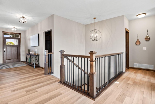 249 3rd St SW, Delano, MN 55328 - hall featuring wood finished floors, a chandelier, an upstairs landing, and baseboards