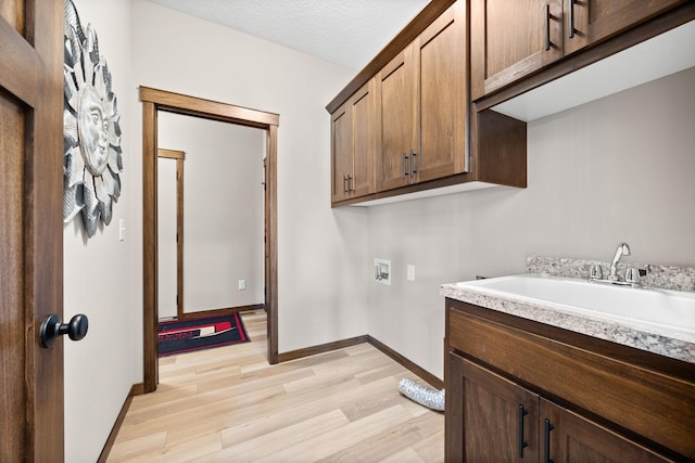 249 3rd St SW, Delano, MN 55328 - laundry room featuring washer hookup, light wood-type flooring, cabinet space, and baseboards