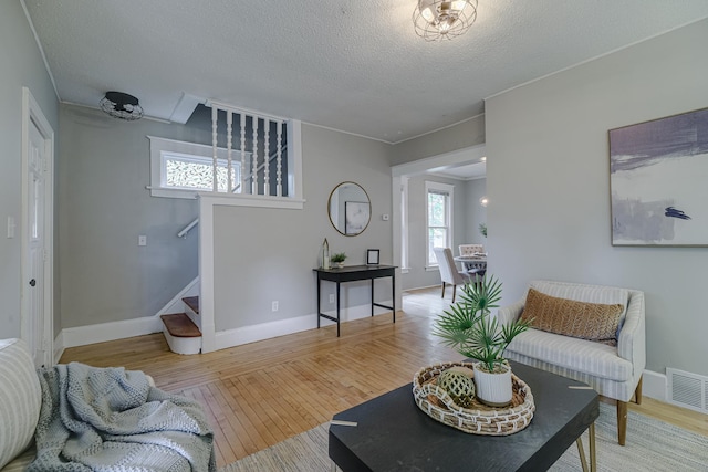 1066 Reaney Ave, Saint Paul, MN 55106 - living room featuring stairway, wood finished floors, a textured ceiling, and baseboards