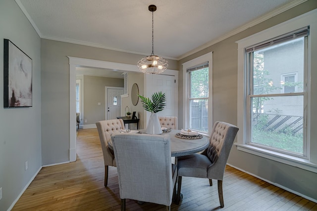 1066 Reaney Ave, Saint Paul, MN 55106 - dining space with light wood-type flooring, baseboards, and ornamental molding