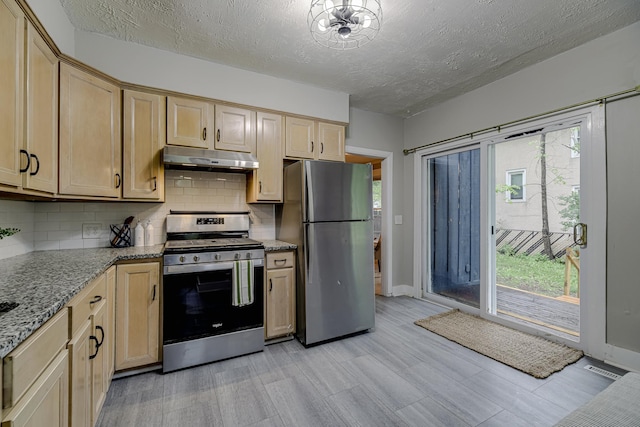 1066 Reaney Ave, Saint Paul, MN 55106 - kitchen featuring stainless steel appliances, under cabinet range hood, backsplash, light wood-style floors, and a textured ceiling