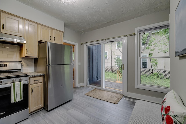 1066 Reaney Ave, Saint Paul, MN 55106 - kitchen with appliances with stainless steel finishes, under cabinet range hood, tasteful backsplash, light brown cabinets, and a textured ceiling