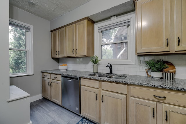 1066 Reaney Ave, Saint Paul, MN 55106 - kitchen with stainless steel dishwasher, a sink, backsplash, light stone countertops, and baseboards
