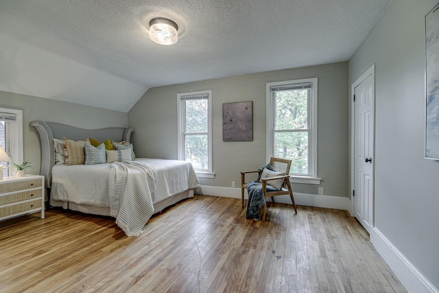 1066 Reaney Ave, Saint Paul, MN 55106 - bedroom featuring a textured ceiling, light wood-style flooring, baseboards, and lofted ceiling