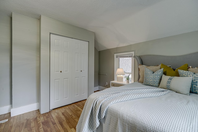 1066 Reaney Ave, Saint Paul, MN 55106 - bedroom featuring hardwood / wood-style flooring, a closet, baseboards, and lofted ceiling
