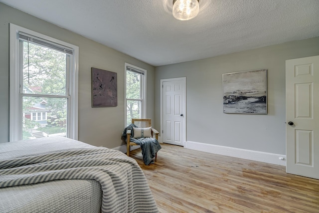1066 Reaney Ave, Saint Paul, MN 55106 - bedroom featuring light wood-style flooring, baseboards, and a textured ceiling