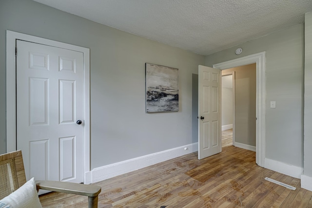 1066 Reaney Ave, Saint Paul, MN 55106 - unfurnished bedroom with light wood-style floors, baseboards, and a textured ceiling