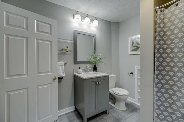 1066 Reaney Ave, Saint Paul, MN 55106 - full bath with vanity, toilet, a textured ceiling, a shower with shower curtain, and wood finished floors