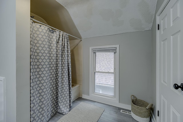 1066 Reaney Ave, Saint Paul, MN 55106 - full bath featuring lofted ceiling, baseboards, shower / tub combo, and a textured ceiling