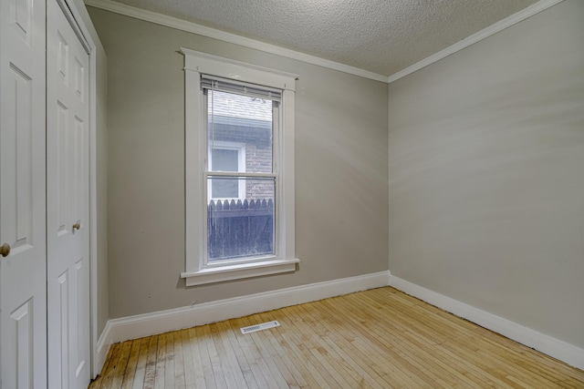 1066 Reaney Ave, Saint Paul, MN 55106 - spare room featuring hardwood / wood-style floors, baseboards, ornamental molding, and a textured ceiling