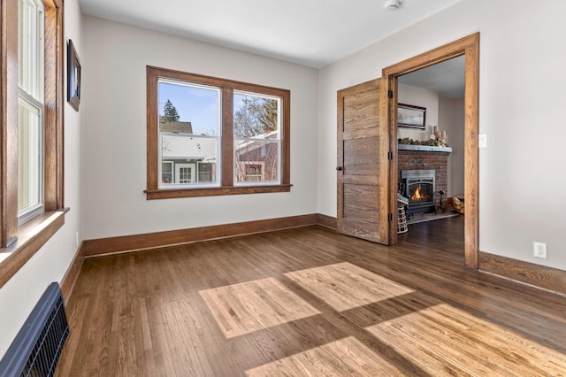 781 7th St, Red Wing, MN 55066 - unfurnished room featuring wood finished floors, baseboards, and a brick fireplace