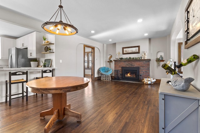 781 7th St, Red Wing, MN 55066 - living room with a brick fireplace, dark wood-style flooring, recessed lighting, and arched walkways