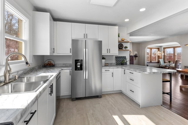 781 7th St, Red Wing, MN 55066 - kitchen with stainless steel appliances, a sink, a peninsula, arched walkways, and healthy amount of natural light