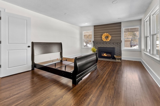 781 7th St, Red Wing, MN 55066 - bedroom featuring wood finished floors, a fireplace, baseboards, and a textured ceiling