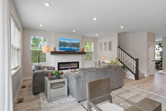 7602 Connie Ln, Inver Grove Heights, MN 55076 - living area featuring light wood finished floors, baseboards, stairway, a glass covered fireplace, and recessed lighting