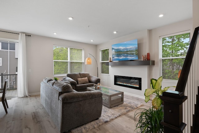 7602 Connie Ln, Inver Grove Heights, MN 55076 - living area featuring wood finished floors, plenty of natural light, a glass covered fireplace, recessed lighting, and baseboards