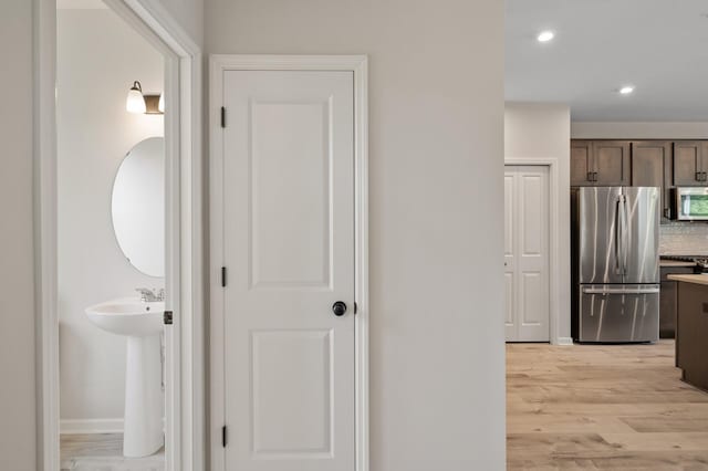 7602 Connie Ln, Inver Grove Heights, MN 55076 - corridor featuring light wood-style floors, recessed lighting, baseboards, and a sink