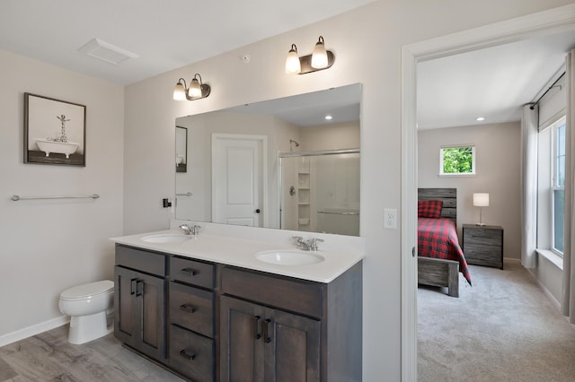 7602 Connie Ln, Inver Grove Heights, MN 55076 - bathroom with double vanity, toilet, baseboards, a shower, and connected bathroom