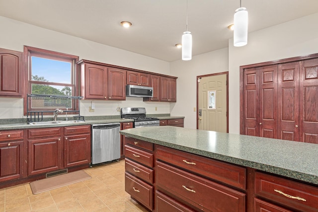 338 Aurora Ave, Saint Paul, MN 55103 - kitchen with appliances with stainless steel finishes, a sink, dark brown cabinets, pendant lighting, and dark countertops