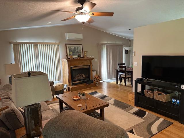 26722 Eisenmen Dr, Leonard, MN 56652 - living room featuring a ceiling fan, wood finished floors, an AC wall unit, crown molding, and lofted ceiling